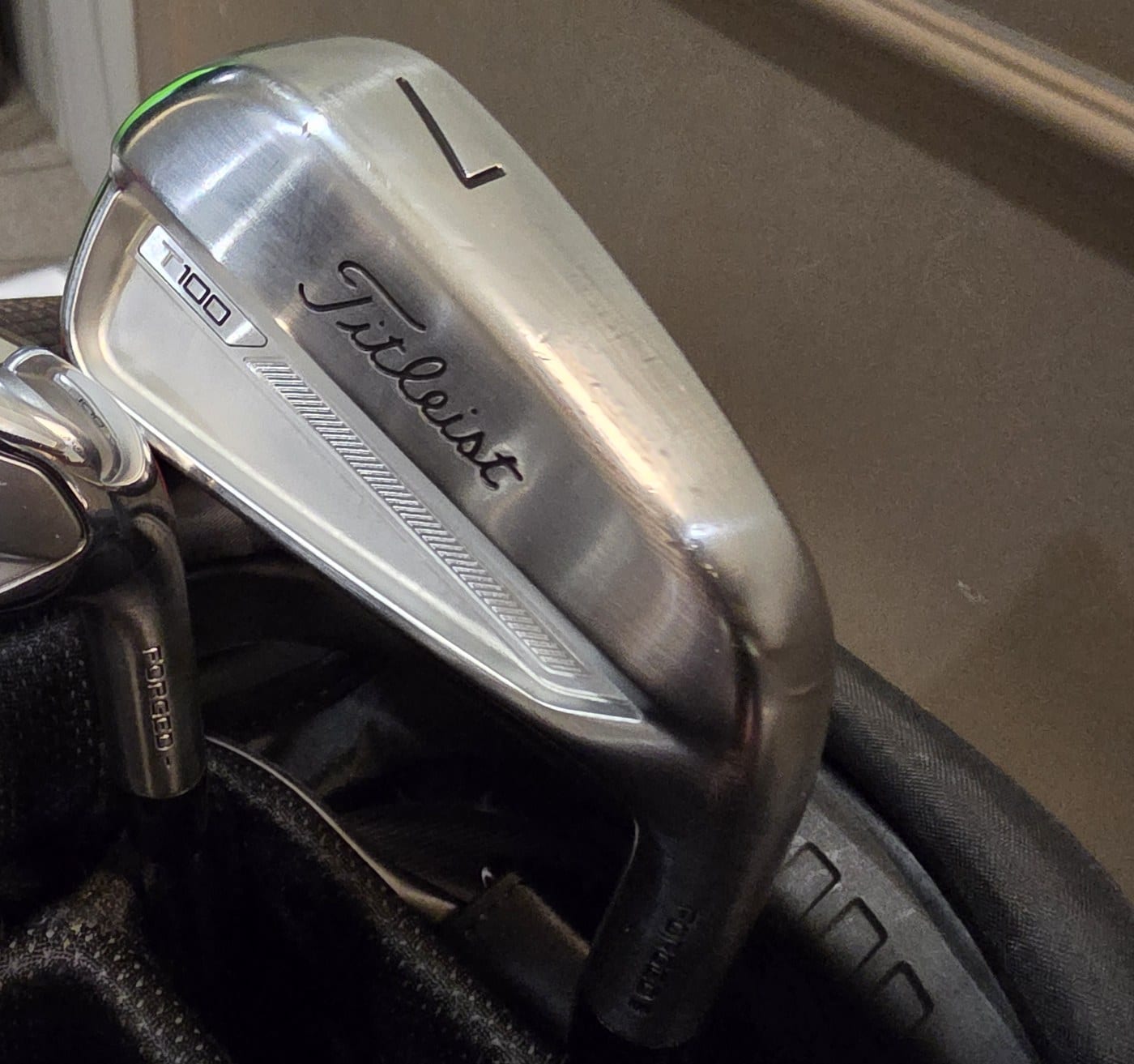 The head of a Titleist T100 7-iron, with the number 7 on the toe and the T100 badge on the cavity.