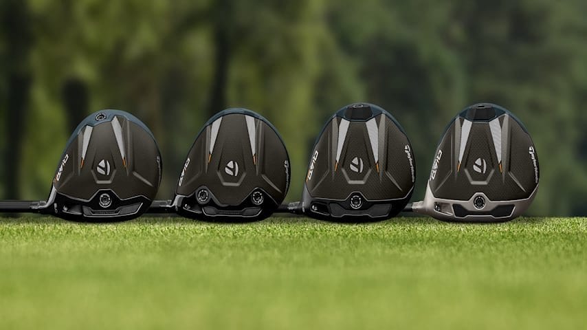 Four TaylorMade Qi4D driver heads lined up crown-up on grass, showing the full Qi4D family lineup.