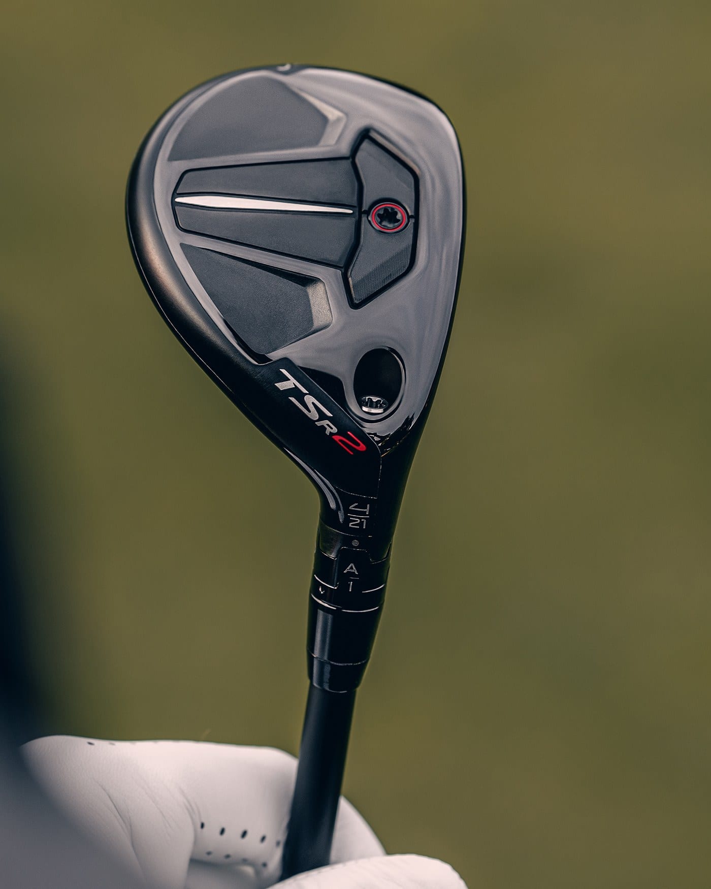 A Titleist TSR2 hybrid held sole-up, showing the SureFit adapter sleeve between head and shaft.