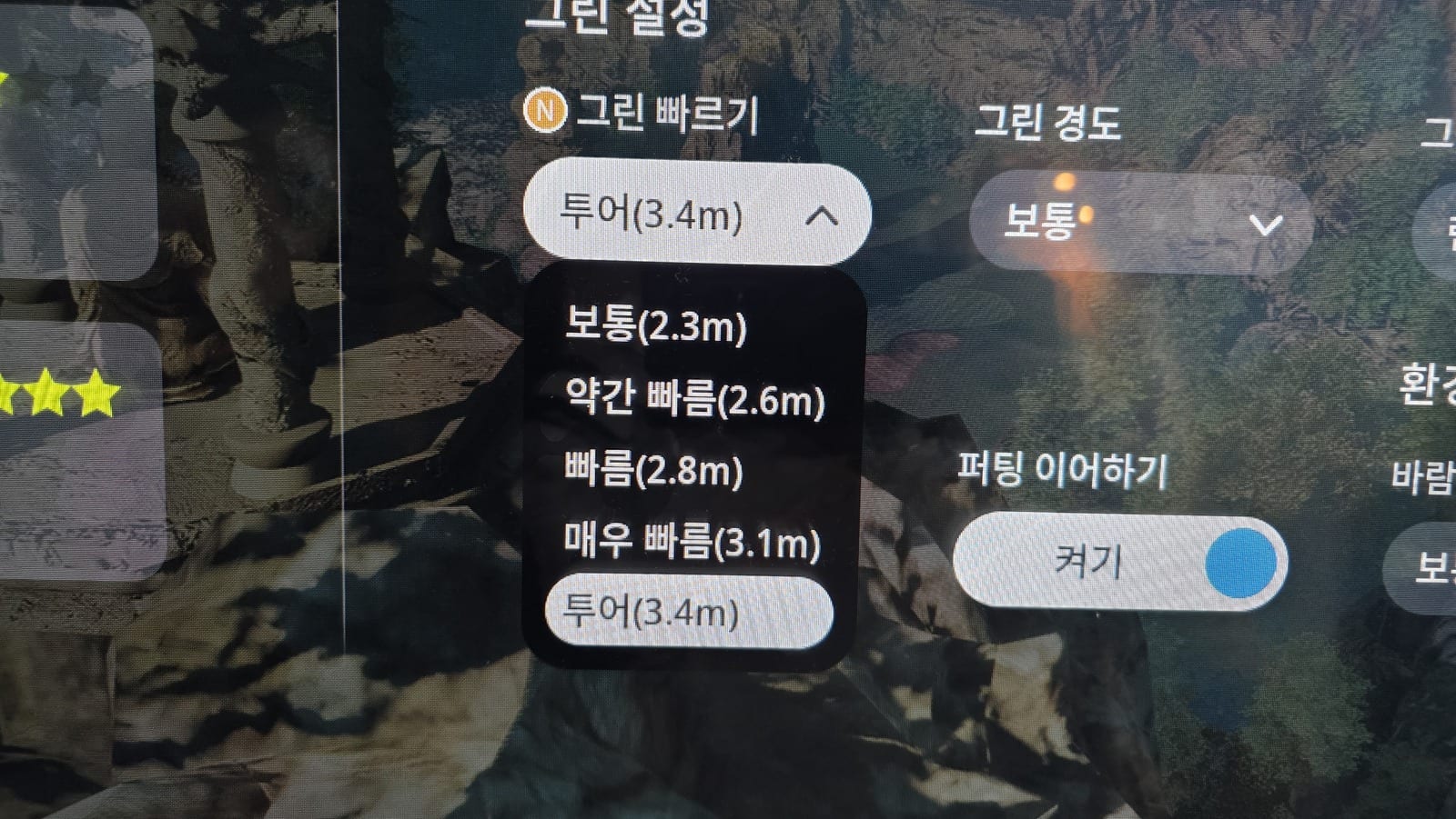 A golf simulator setup screen headed 그린 설정, with an open dropdown under 그린 빠르기 listing five options in Korean with a number beside each: 보통 2.3m, 약간 빠름 2.6m, 빠름 2.8m, 매우 빠름 3.1m, and 투어 3.4m highlighted as the selected one. An orange circled N badge sits to the left of the 그린 빠르기 label, and a second dropdown to the right reads 그린 경도 set to 보통.