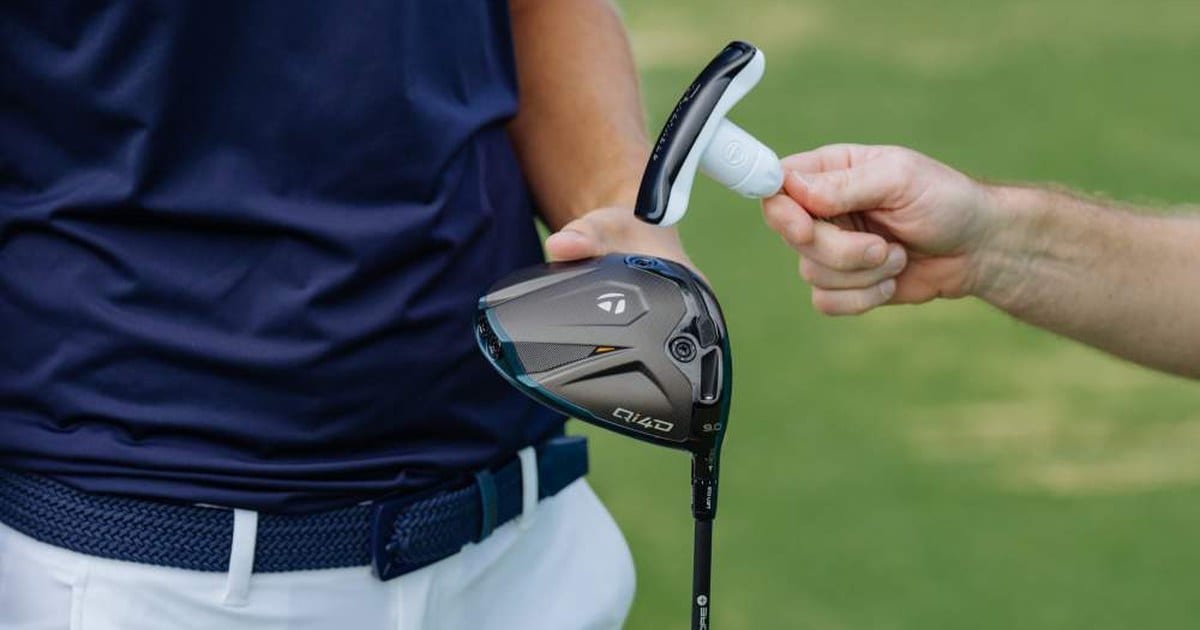 A hand passing a TaylorMade wrench to a golfer holding a Qi4D driver sole out, with the 9.0 loft stamp showing.