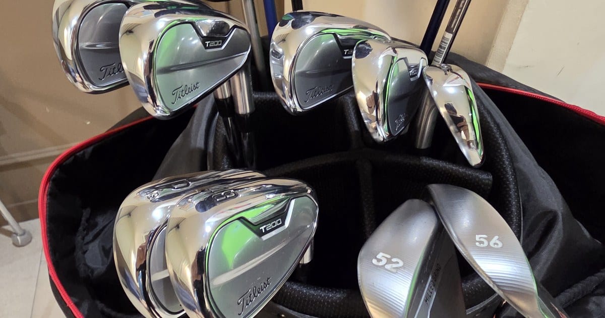 A friend's 2021 Titleist T200 irons standing in his golf bag, next to his TaylorMade 52 and 56 degree wedges.